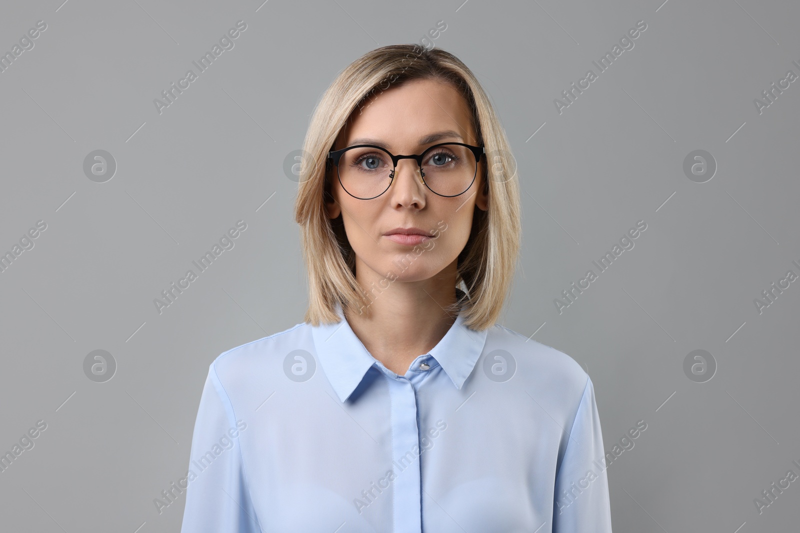 Photo of Portrait of businesswoman in glasses on gray background