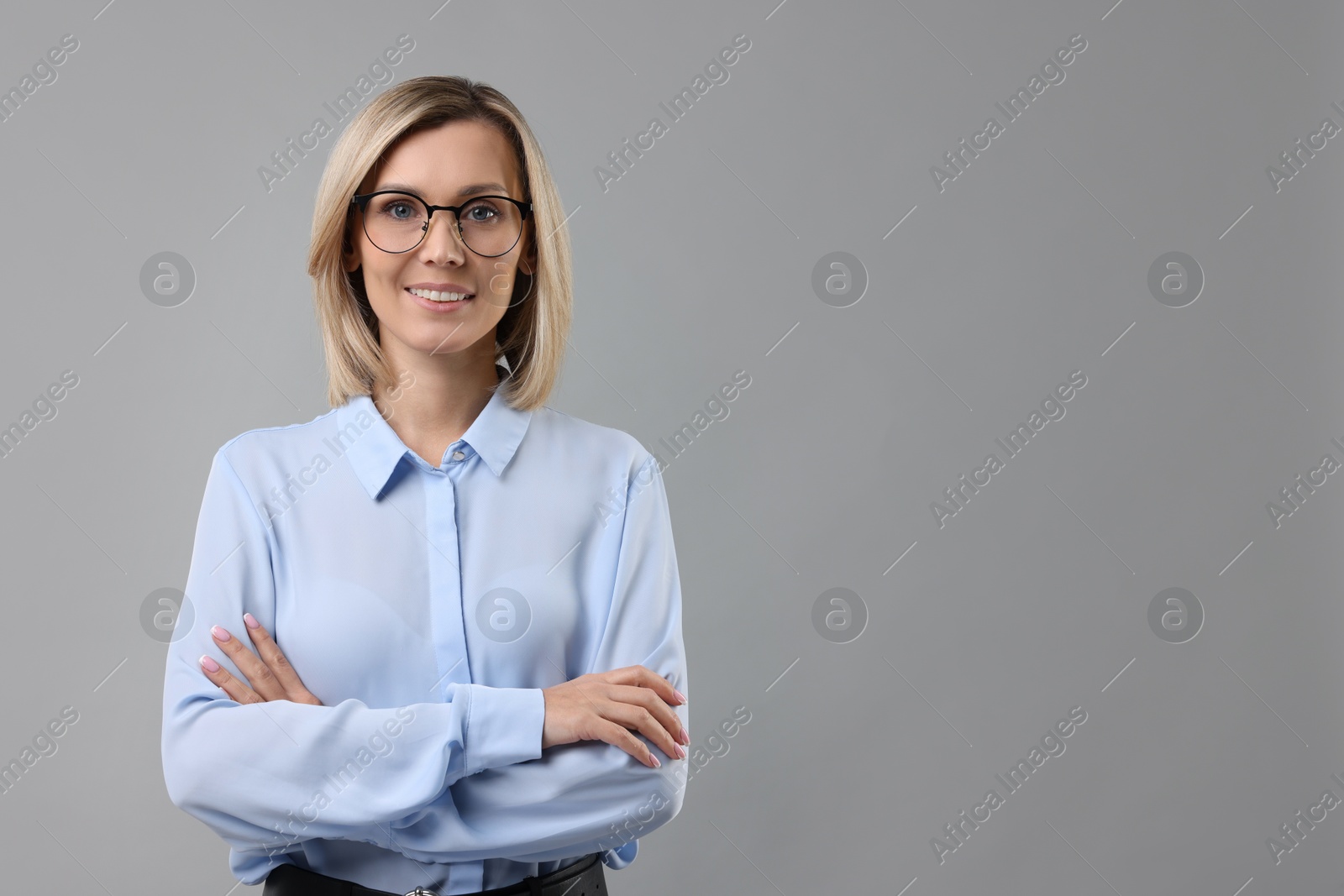 Photo of Portrait of businesswoman in glasses on gray background, space for text