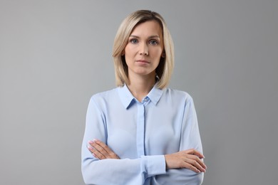 Photo of Portrait of businesswoman in light blue shirt on gray background