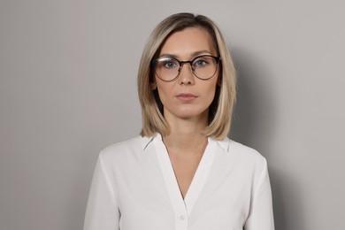 Photo of Portrait of businesswoman in glasses on gray background