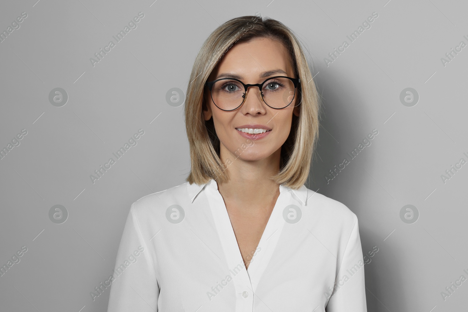 Photo of Portrait of businesswoman in glasses on gray background