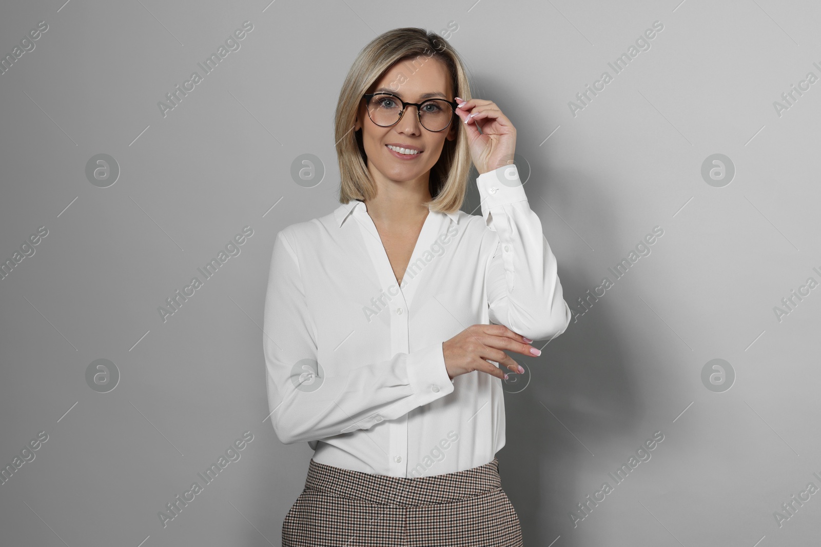 Photo of Portrait of businesswoman in glasses on gray background