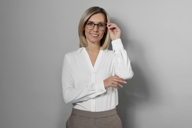 Photo of Portrait of businesswoman in glasses on gray background