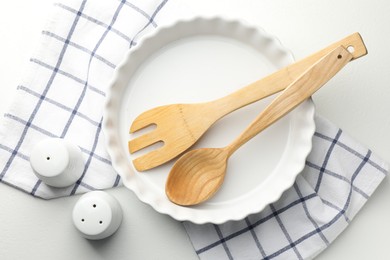 Photo of Ceramic casserole and other cooking utensils on white table, top view