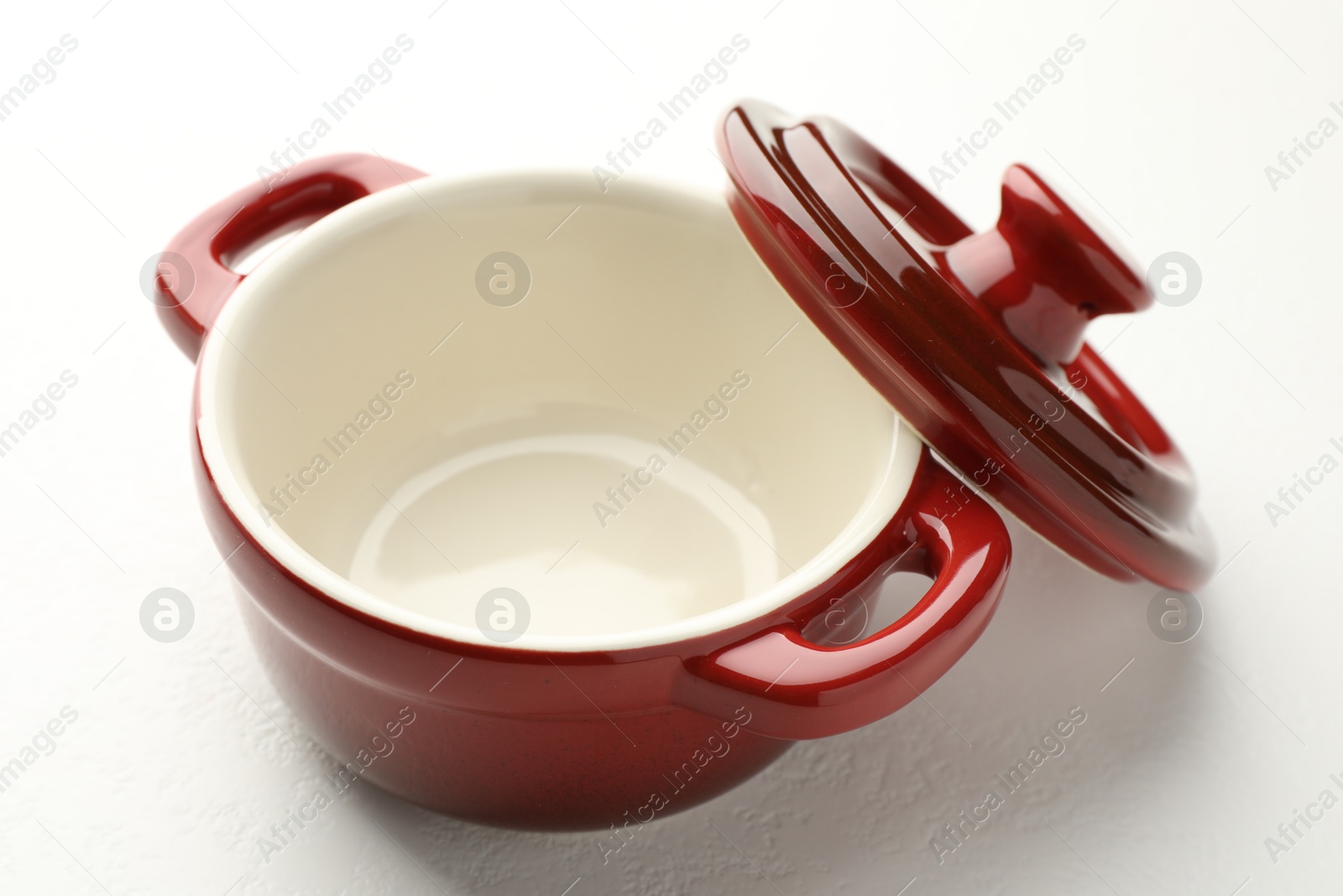 Photo of Ceramic casserole and lid on white table, closeup