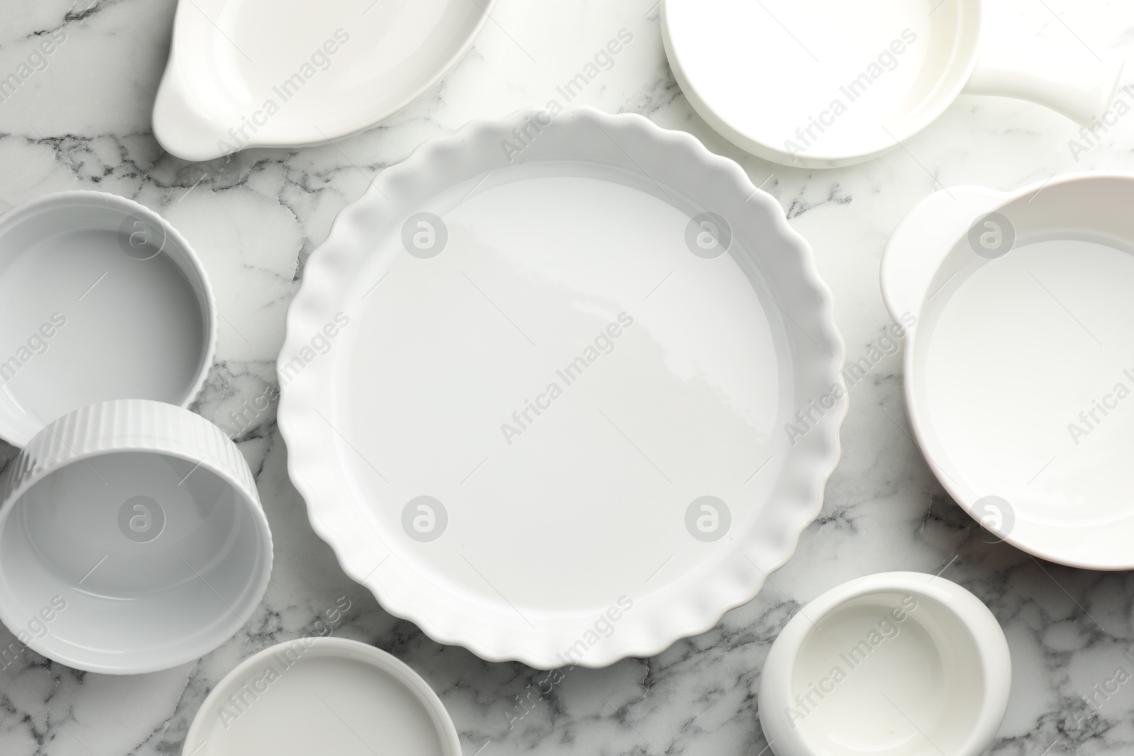 Photo of Different casseroles on white marble table, flat lay