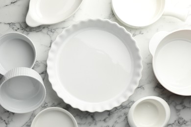 Photo of Different casseroles on white marble table, flat lay