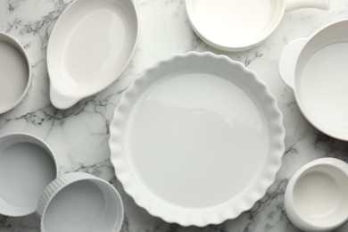 Photo of Different casseroles on white marble table, flat lay