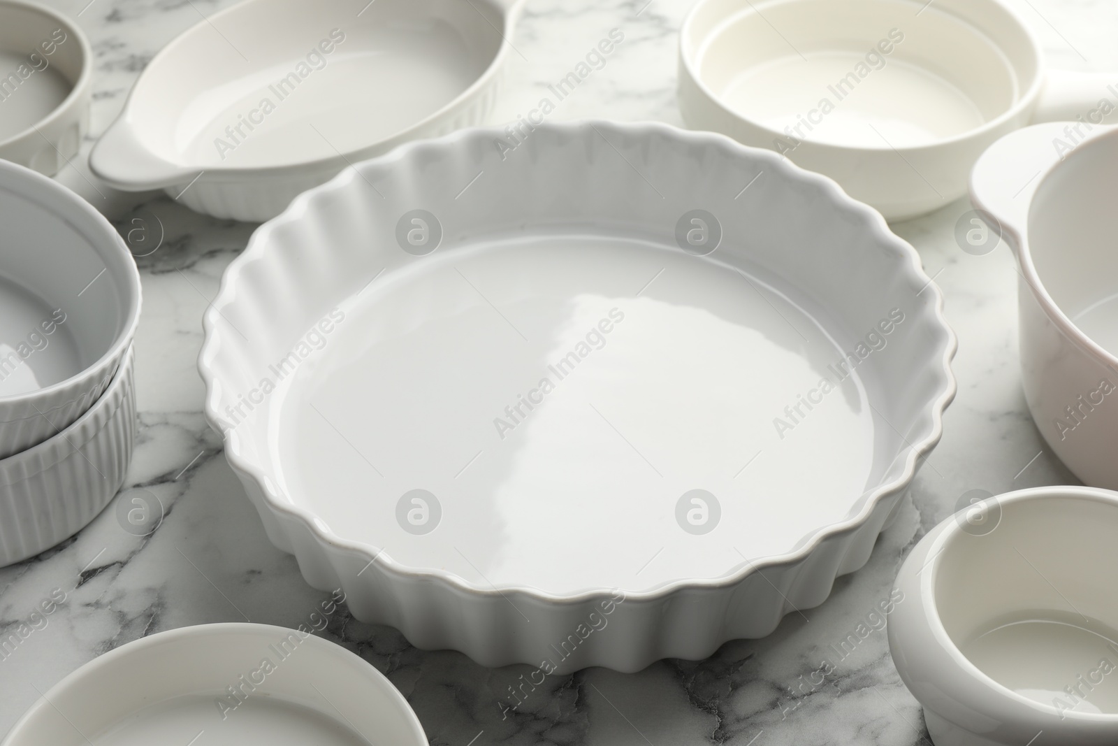 Photo of Different casseroles on white marble table, closeup