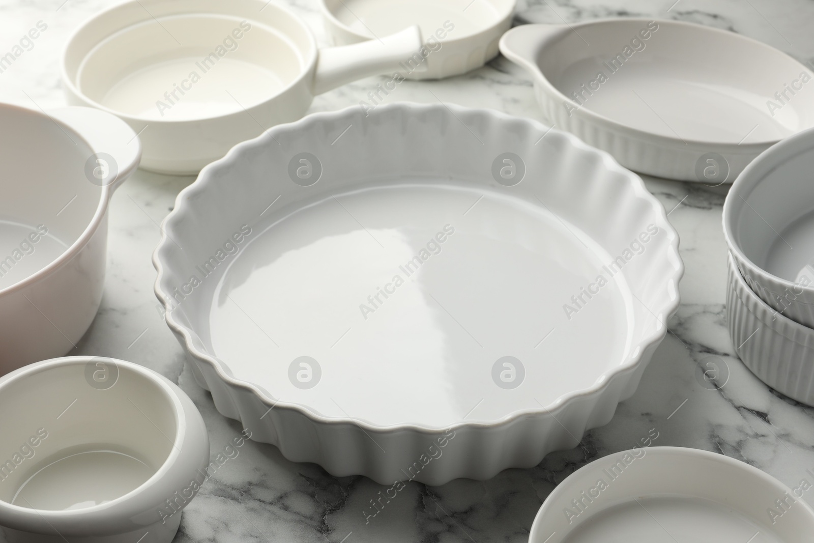 Photo of Different casseroles on white marble table, closeup