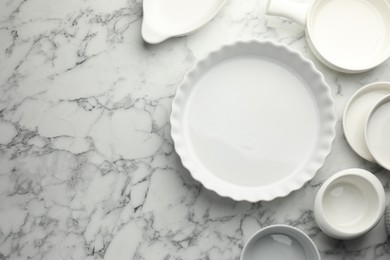 Photo of Different casseroles on white marble table, flat lay. Space for text