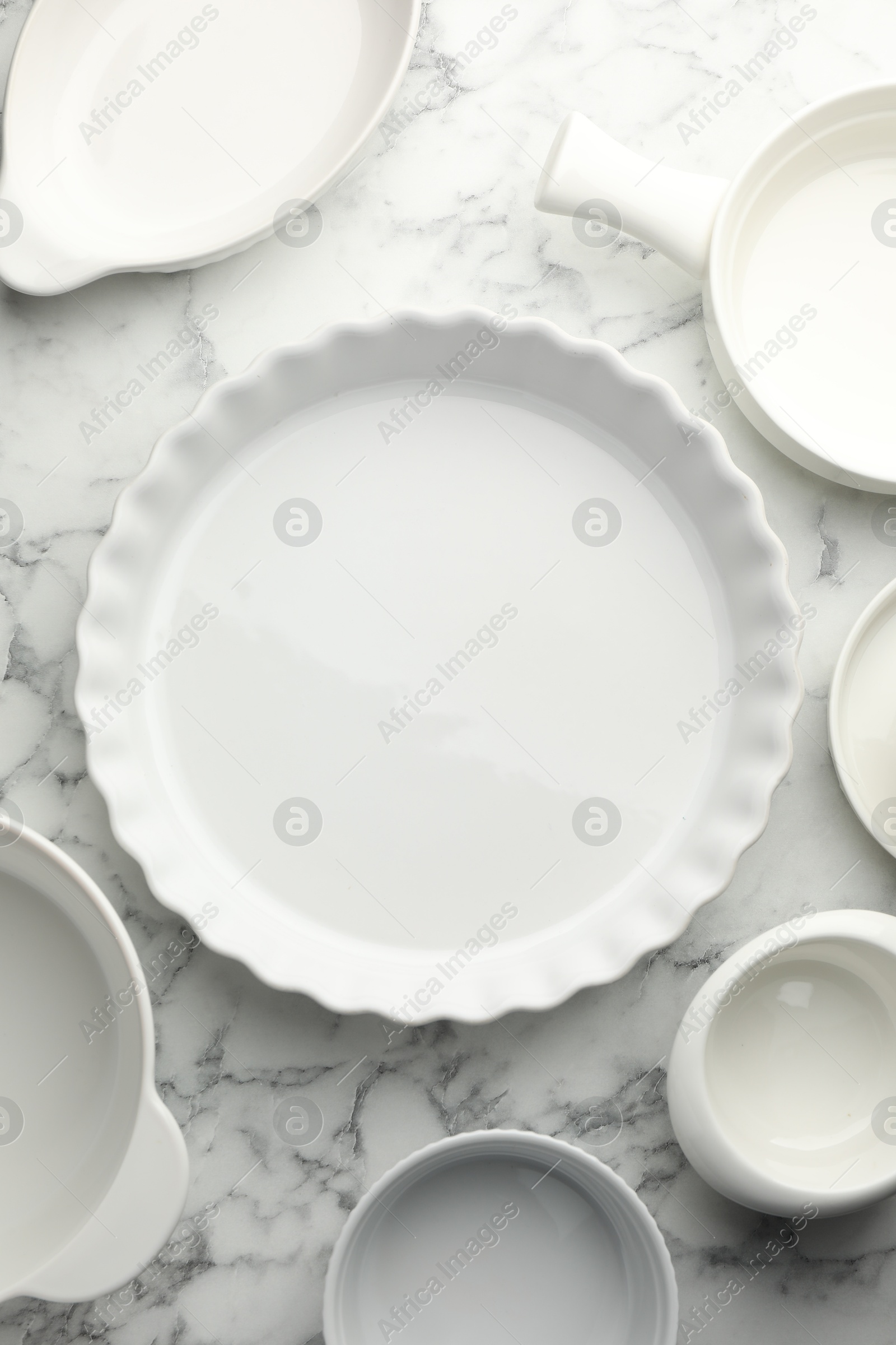 Photo of Different casseroles on white marble table, flat lay