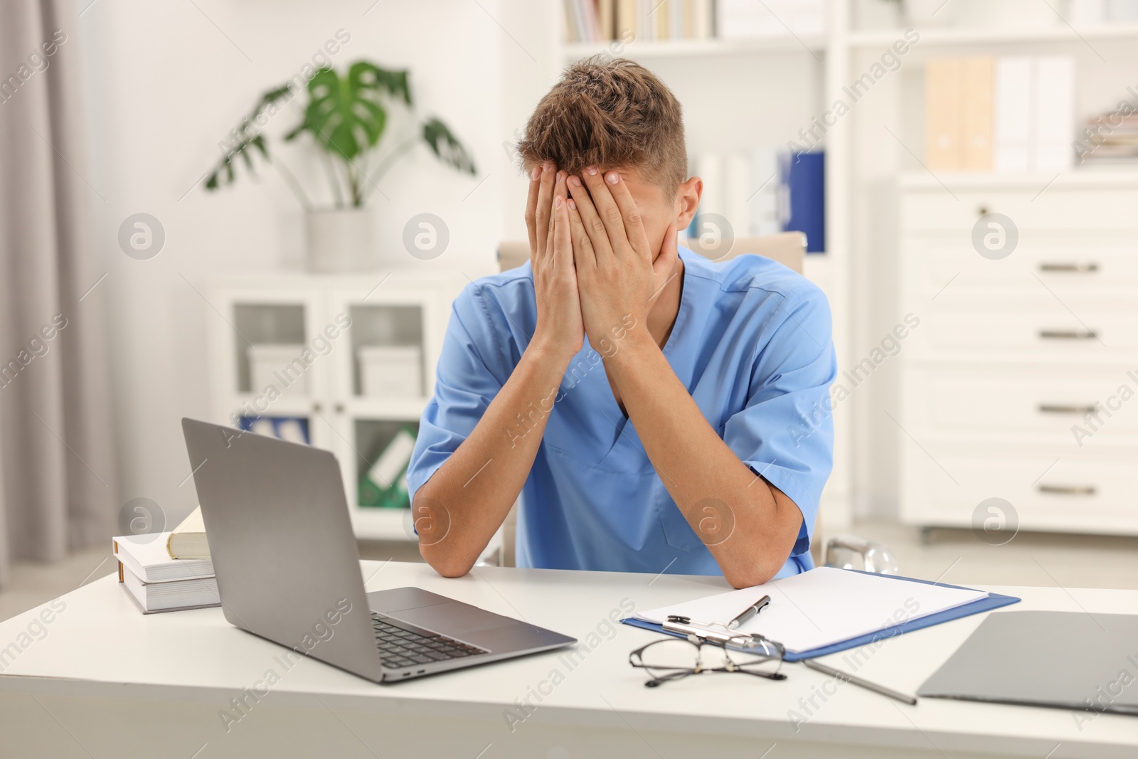 Photo of Medical student in uniform studying at table indoors