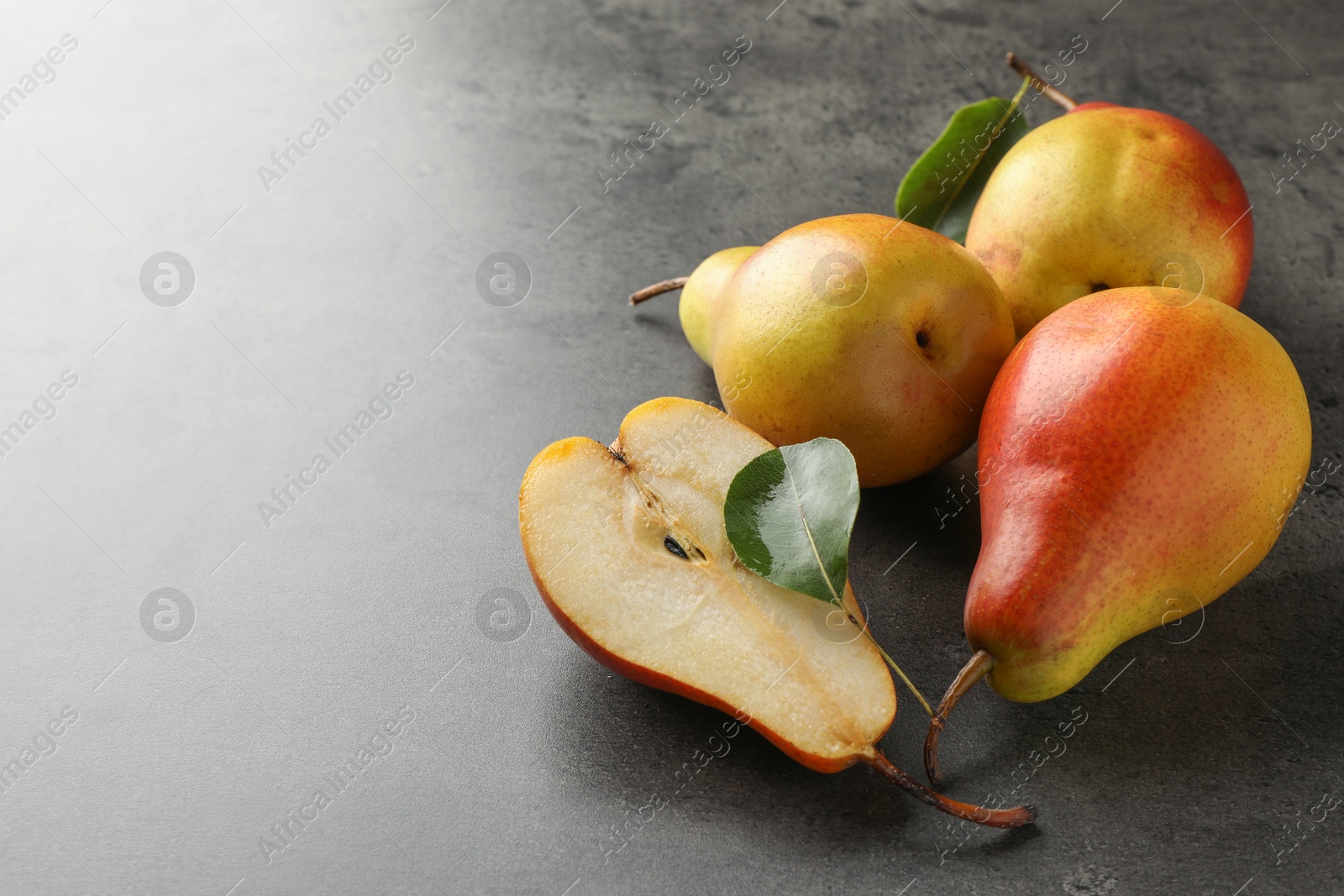 Photo of Ripe juicy pears on grey table, closeup. Space for text