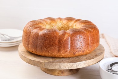 Photo of Freshly baked sponge cake on white wooden table, closeup