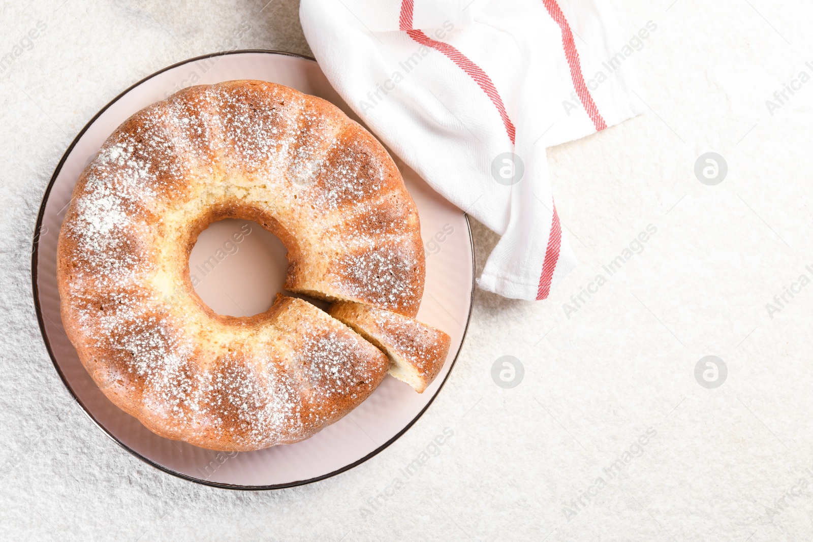 Photo of Freshly baked sponge cake on white textured table, top view. Space for text