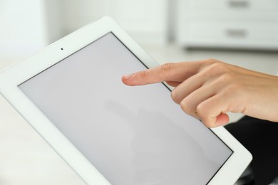 Photo of Businesswoman using tablet indoors, closeup. Modern technology