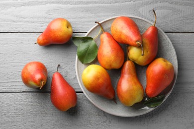 Photo of Ripe juicy pears on grey wooden table, flat lay