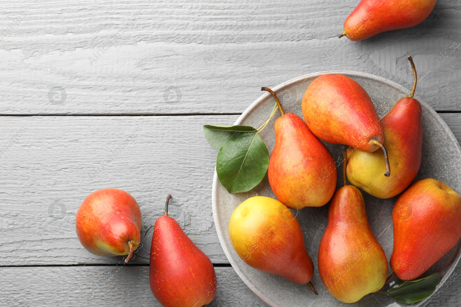 Photo of Ripe juicy pears on grey wooden table, flat lay. Space for text