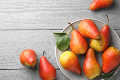 Photo of Ripe juicy pears on grey wooden table, flat lay. Space for text