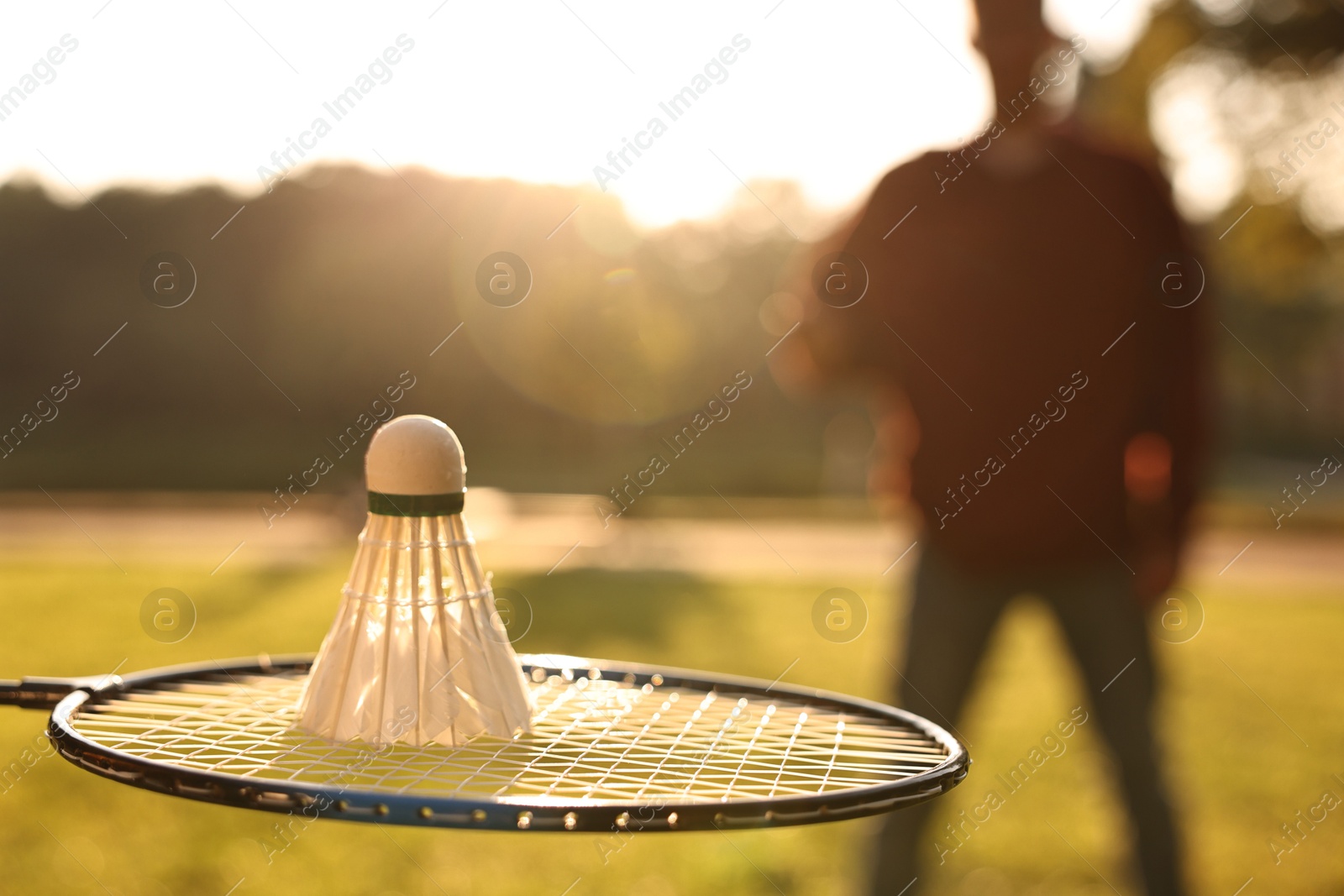 Photo of Badminton racket and shuttlecock in park on sunny day, selective focus