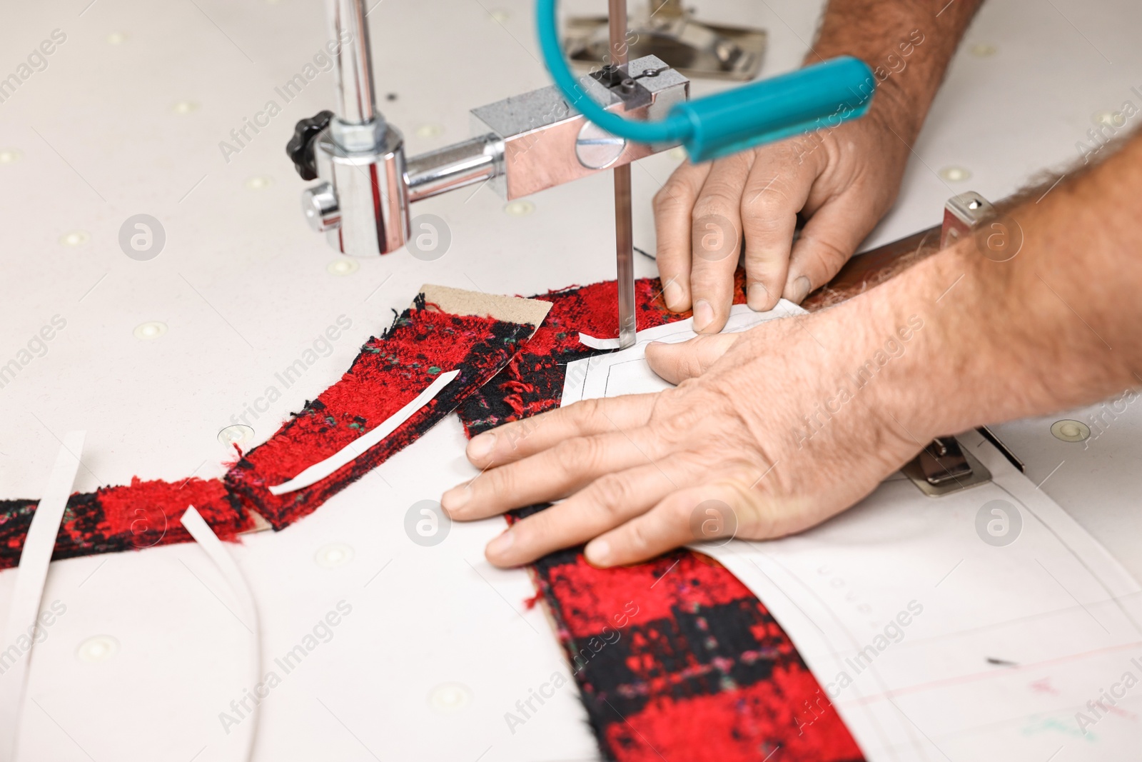 Photo of Man working at white table in professional workshop, closeup