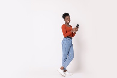 Photo of Happy woman with smartphone on white background. Space for text