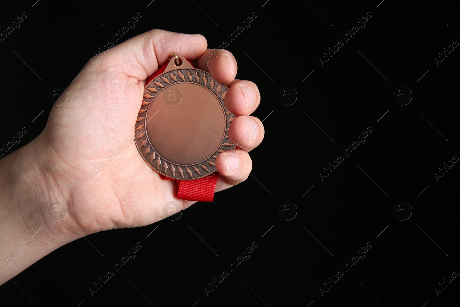 Photo of Man with bronze medal on black background, closeup. Space for text