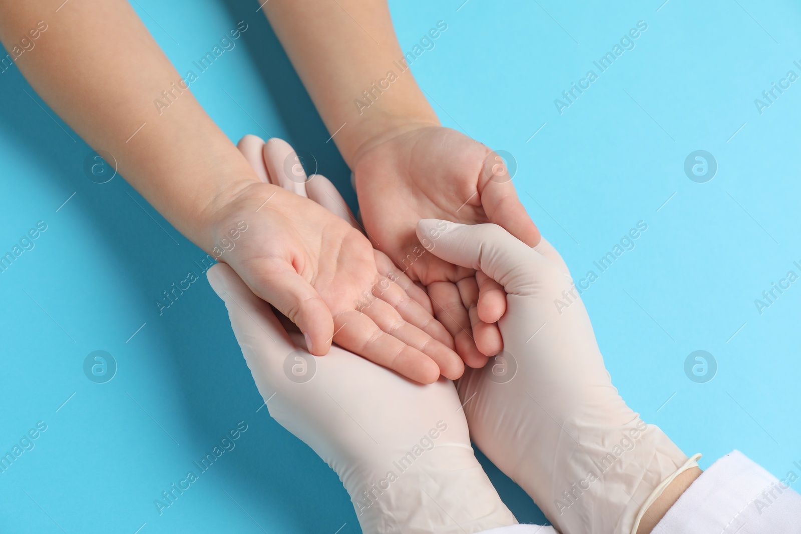 Photo of Doctor and child on light blue background, above view