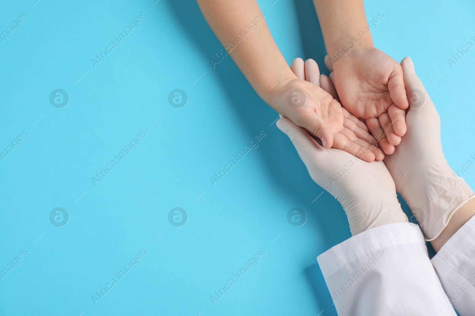 Photo of Doctor and child on light blue background, top view. Space for text