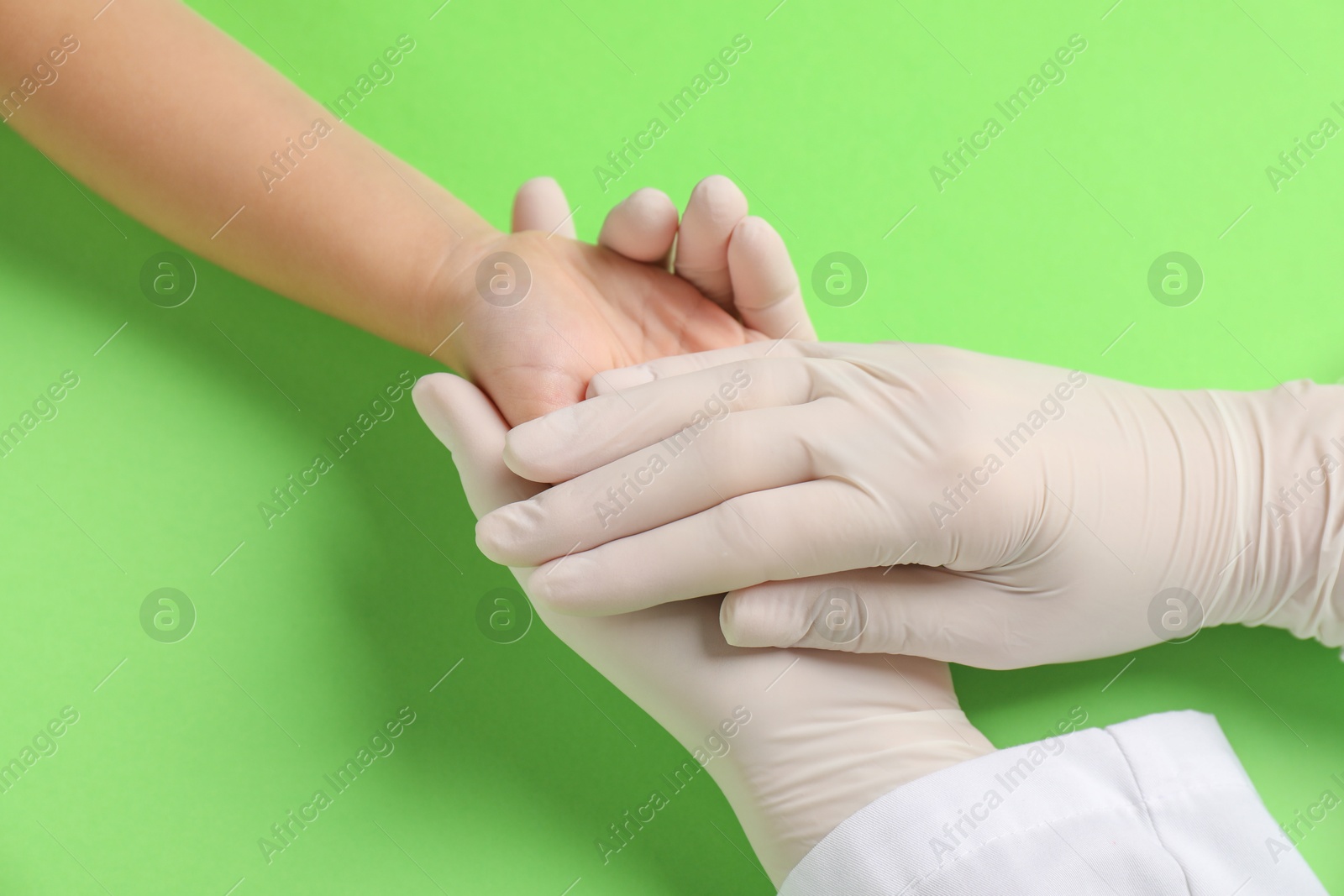 Photo of Doctor and child on light green background, closeup