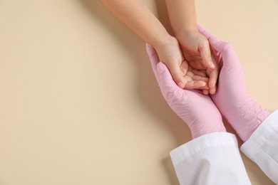 Photo of Doctor and child on beige background, top view. Space for text