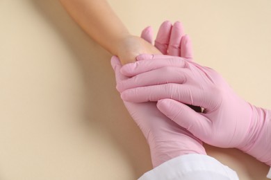 Photo of Doctor and child on beige background, closeup