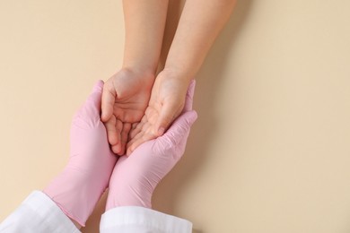 Photo of Doctor and child on beige background, top view. Space for text