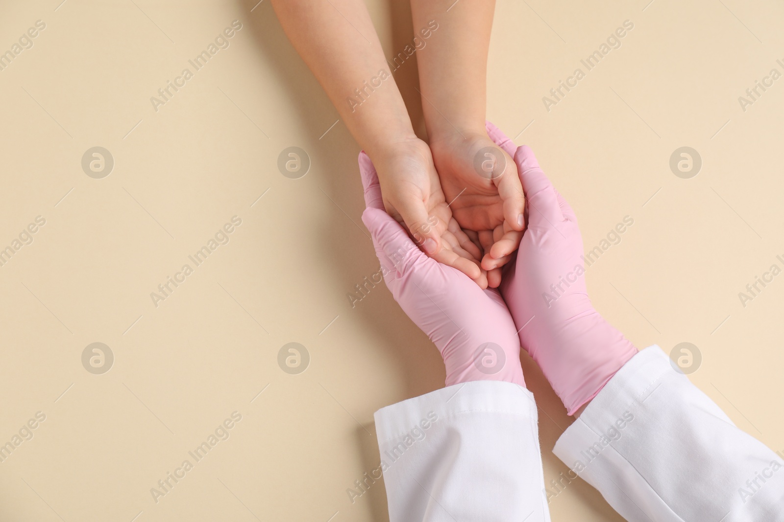 Photo of Doctor and child on beige background, top view. Space for text