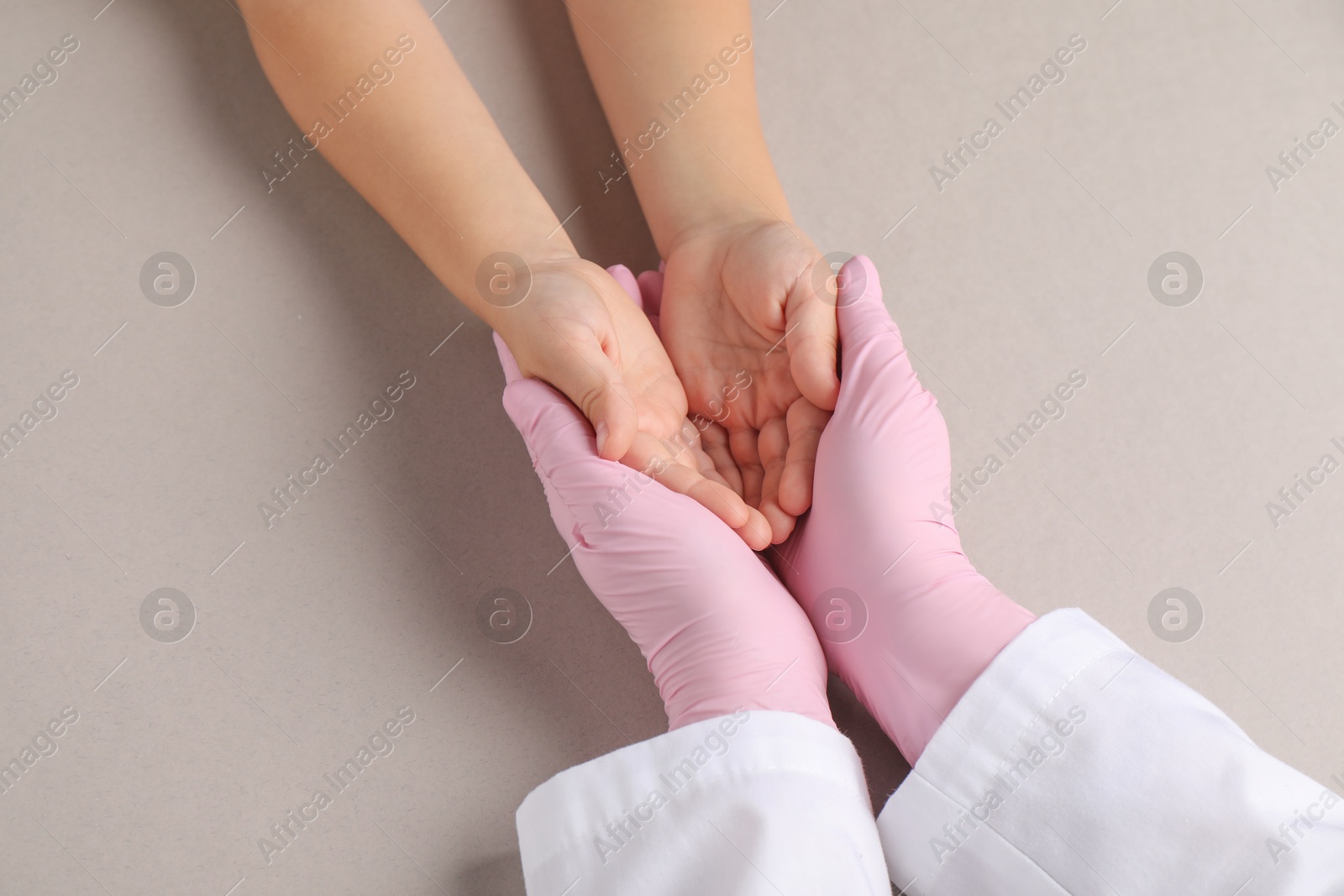 Photo of Doctor and child on light grey background, top view