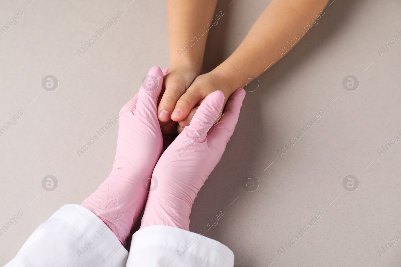 Photo of Doctor and child on light grey background, top view