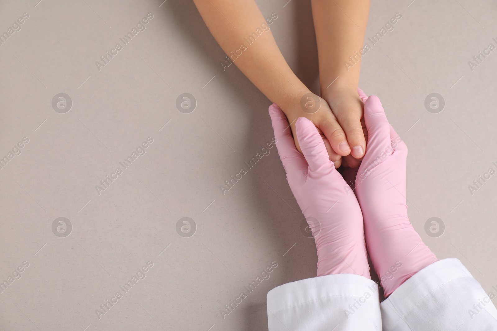 Photo of Doctor and child on light grey background, top view. Space for text