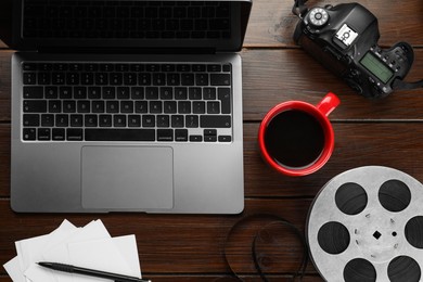 Photo of Flat lay composition with camera, film reel and laptop on wooden table