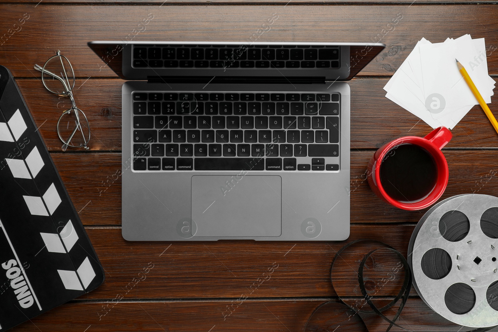 Photo of Flat lay composition with movie clapper, film reel and laptop on wooden table