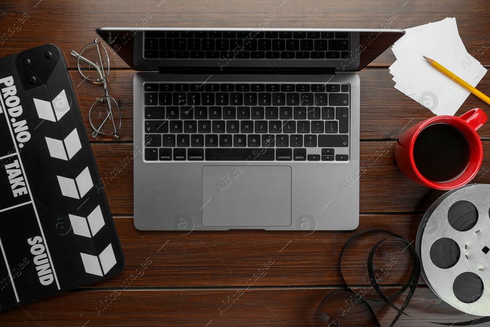 Photo of Flat lay composition with movie clapper, film reel and laptop on wooden table