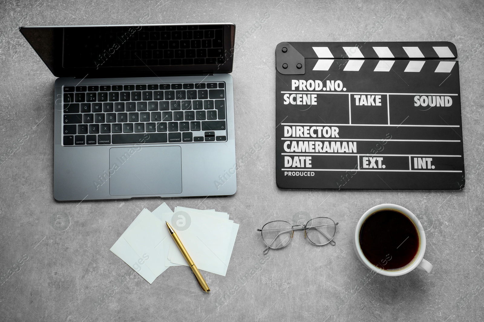 Photo of Flat lay composition with movie clapper and laptop on grey textured table