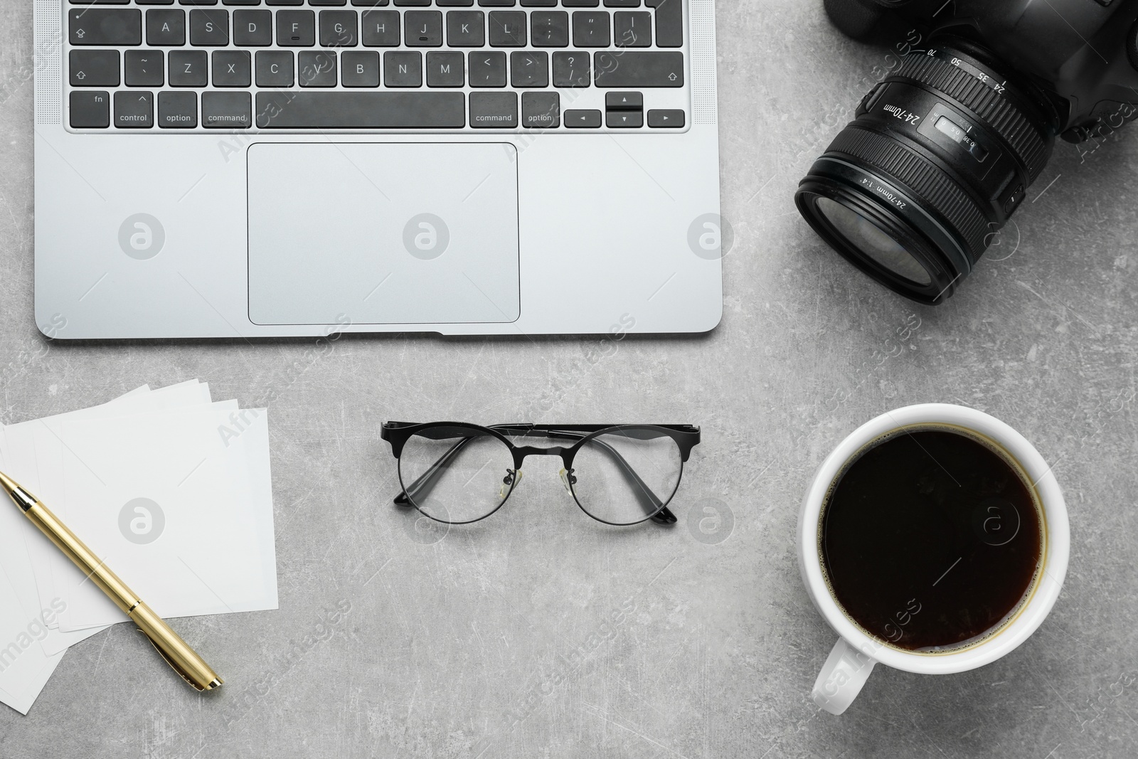 Photo of Flat lay composition with camera and laptop on grey textured table