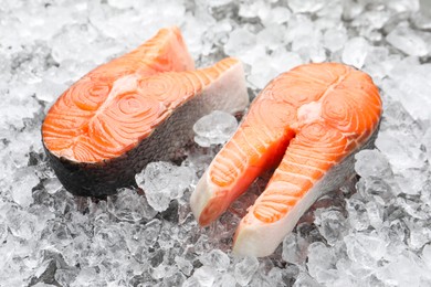 Photo of Fresh raw salmon steaks on ice pieces, closeup