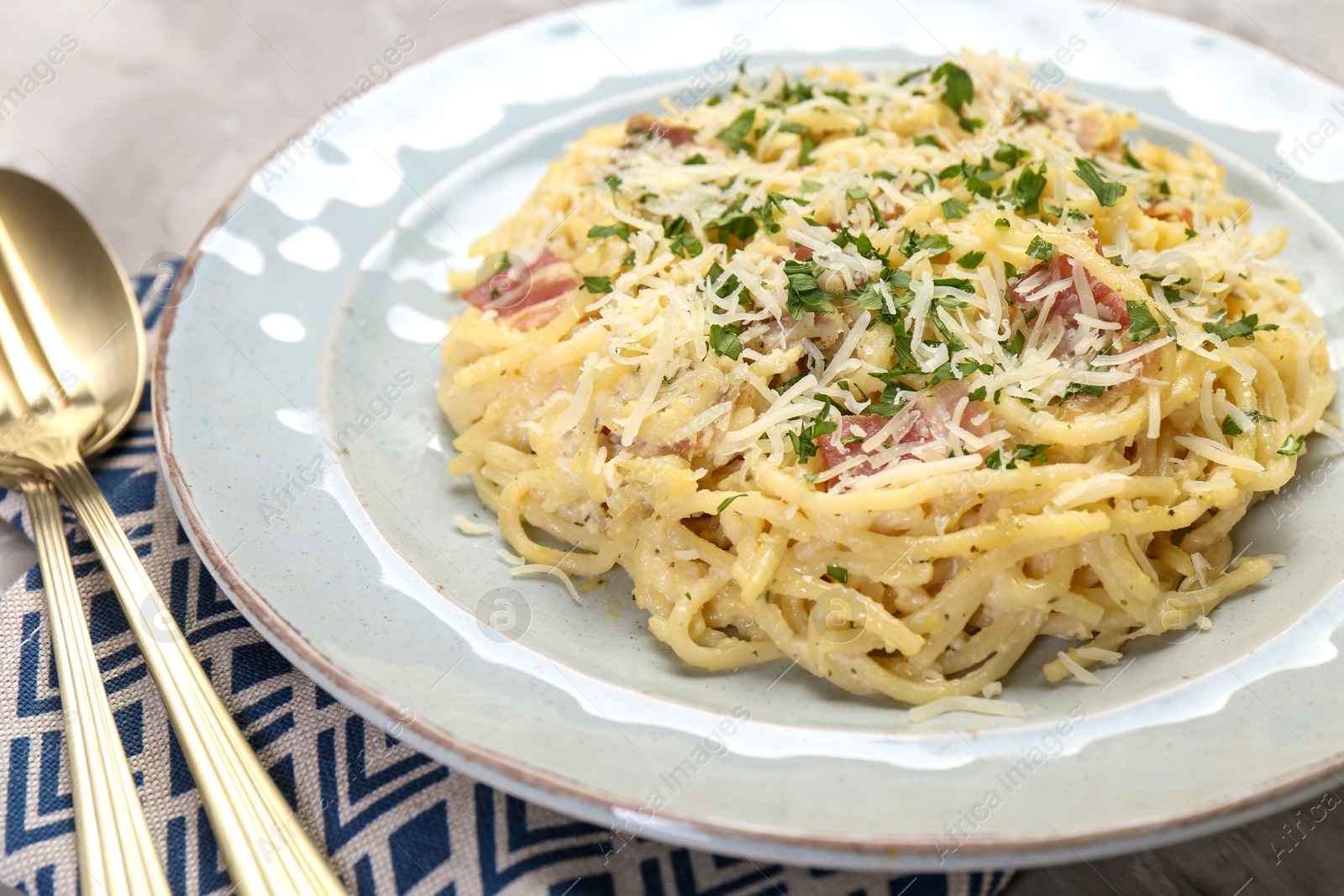 Photo of Delicious pasta Carbonara with bacon served on gray table, closeup