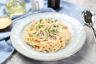 Photo of Delicious pasta Carbonara with bacon served on gray textured table, closeup