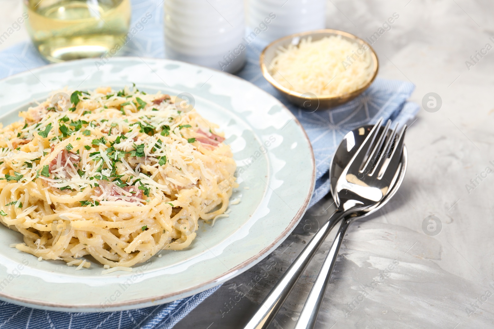 Photo of Delicious pasta Carbonara with bacon served on gray textured table, closeup