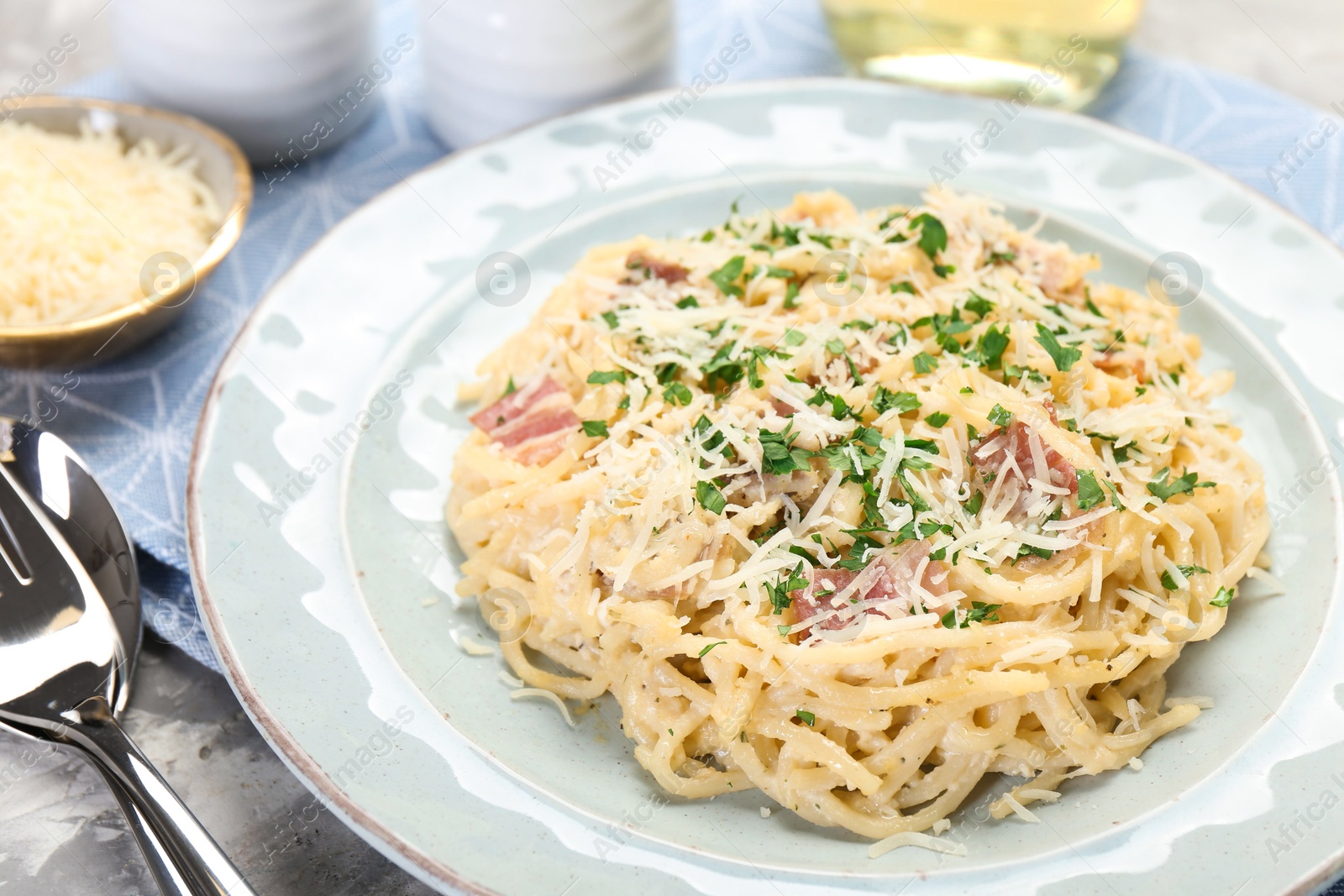 Photo of Delicious pasta Carbonara with bacon served on table, closeup