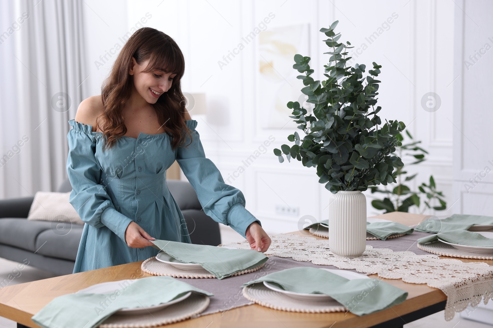 Photo of Woman setting table for dinner at home