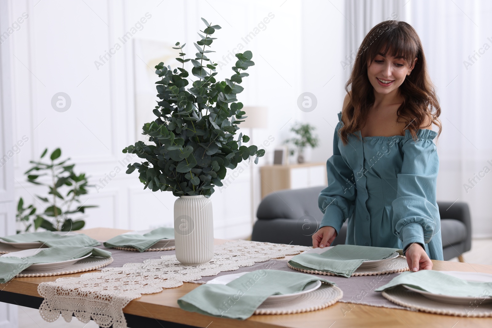 Photo of Woman setting table for dinner at home